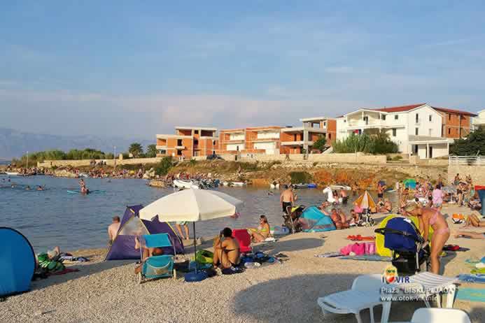 Suncobran i plastične ležaljke na plaži s turistima