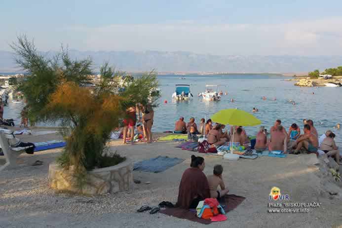 Uživanje gostiju na šljunčanoj plaži uz kamenu žardinjeru sa tamarisom