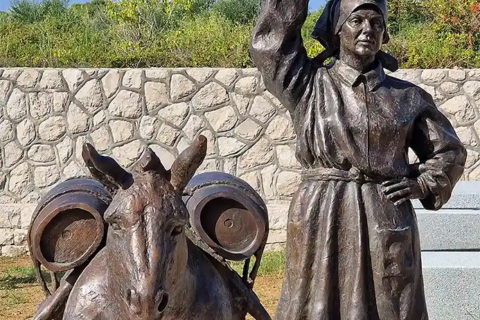 Magarac s burilima i žena koja nosi vodu