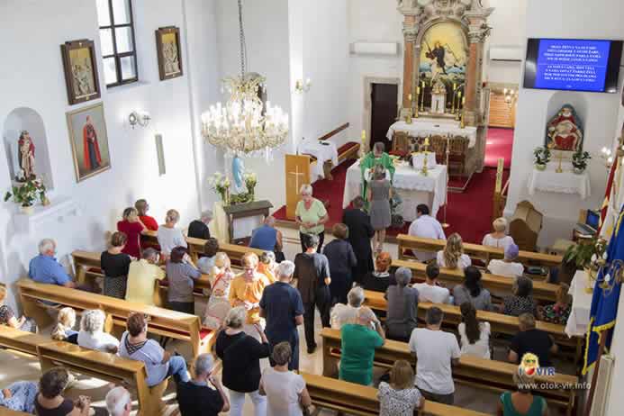 Dijeljenje hostije vjernicima na svetoj misi u župnoj crkvi