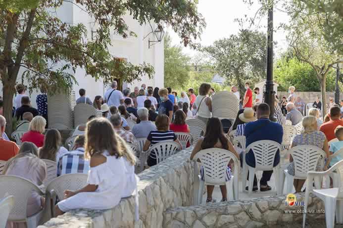 Vjernici sjede na stolicama i slušaju misu ispred župne crkve svetog Jurja u Viru